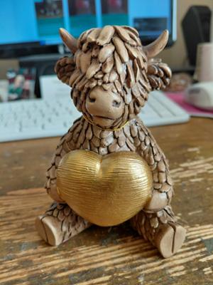 Highland Cow Holding a Gold Heart photo